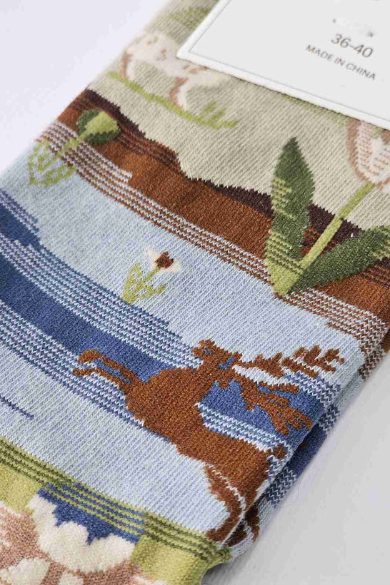 نمای نزدیک بافت جوراب طرح حیوانات و منظره جنگلی