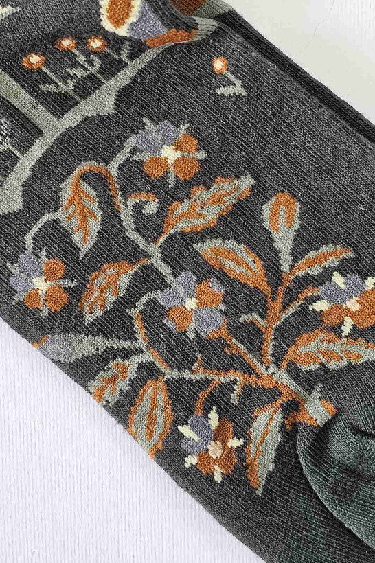 نمای نزدیک بافت جوراب طرح گل و برگ با جزئیات رنگی