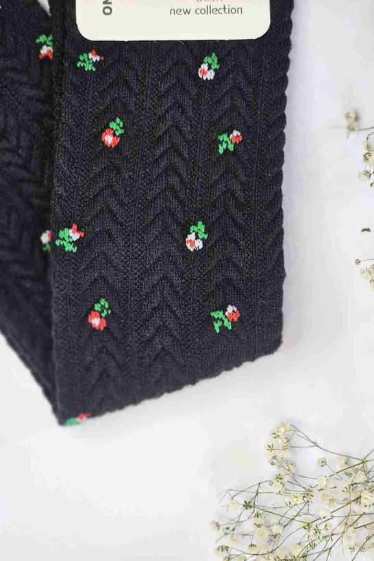 نمای نزدیک بافت گندمی و گلهای ریز جوراب کودک